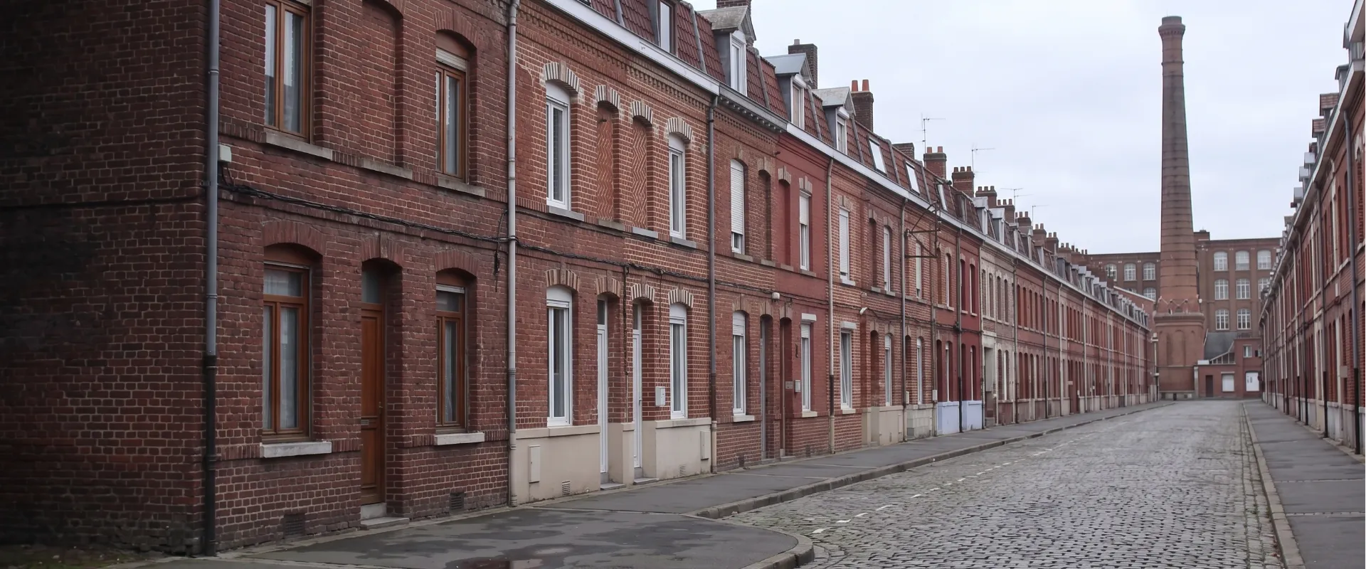 Rue de maisons ouvrières en brique à Roubaix, avec cheminée d'usine textile en arrière-plan